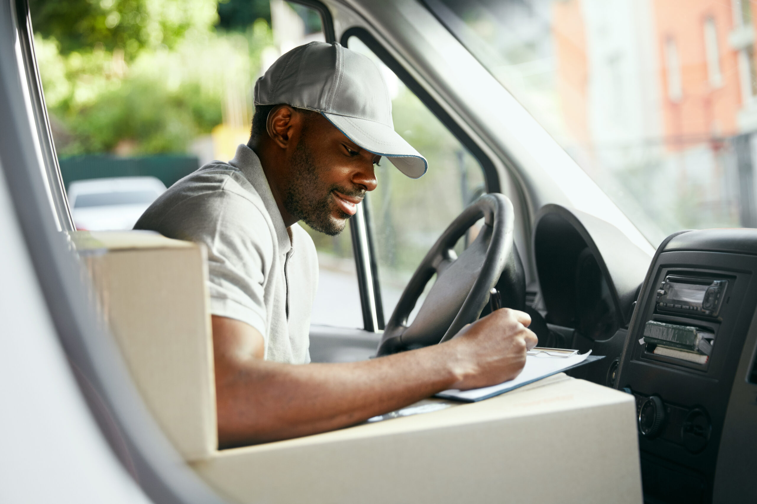 Man smiling in the van while writing on a piece of paper