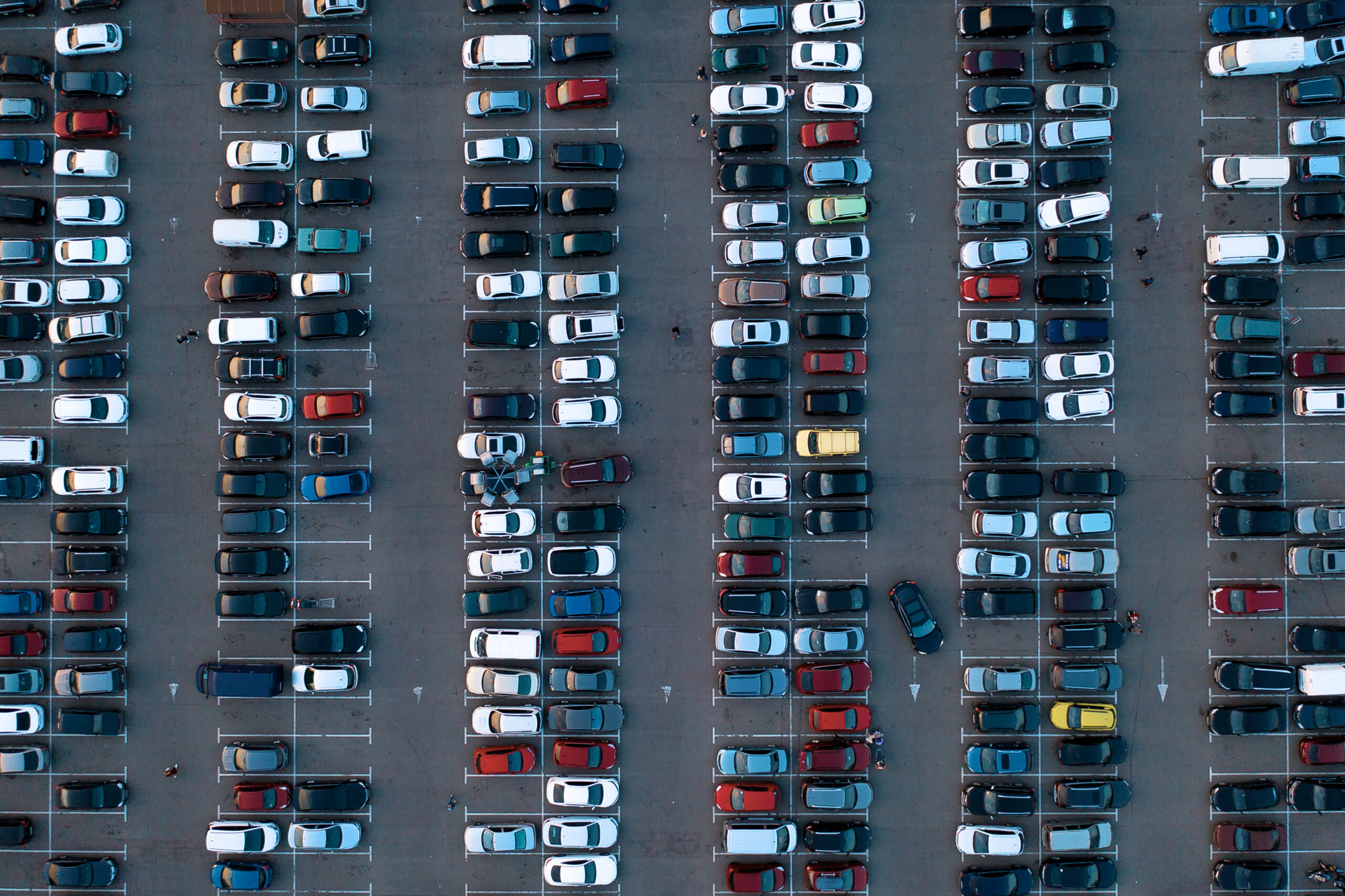 Picture from above of a parking lot with rows of cars